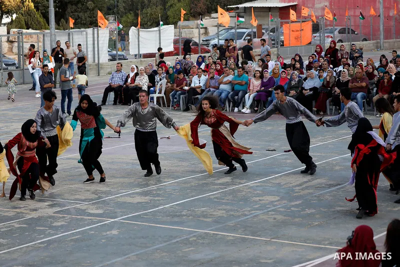 Palestinian youth perform traditional Palestinian dance during the Festival of the movement of Palestinian National Initiative Mustafa Barghouti in West Bank city of Bethlehem on August 12, 2017. Photo by Wisam Hashlamou...