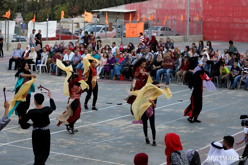 Palestinian youth perform traditional Palestinian dance during the Festival of the movement of Palestinian National Initiative Mustafa Barghouti in West Bank city of Bethlehem on August 12, 2017. Photo by Wisam Hashlamou...