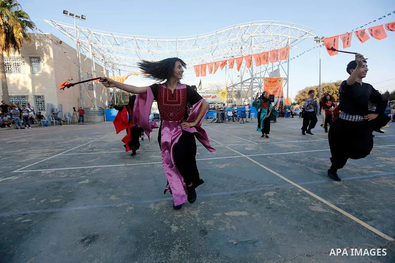 Palestinian youth perform traditional Palestinian dance during the Festival of the movement of Palestinian National Initiative Mustafa Barghouti in West Bank city of Bethlehem on August 12, 2017. Photo by Wisam Hashlamou...