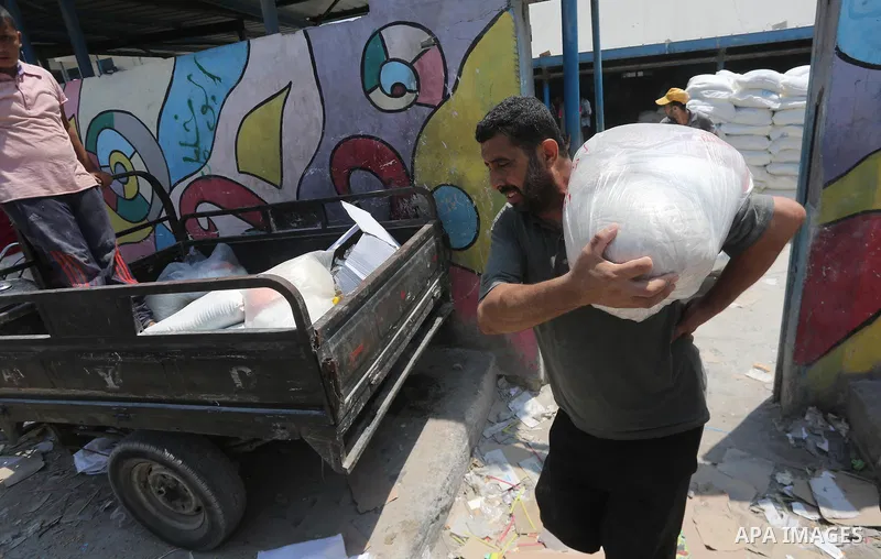 Palestinians receive their monthly food aid at a United Nations distribution center (UNRWA) in Gaza city on August 13, 2017. Photo by Mohammed Asad