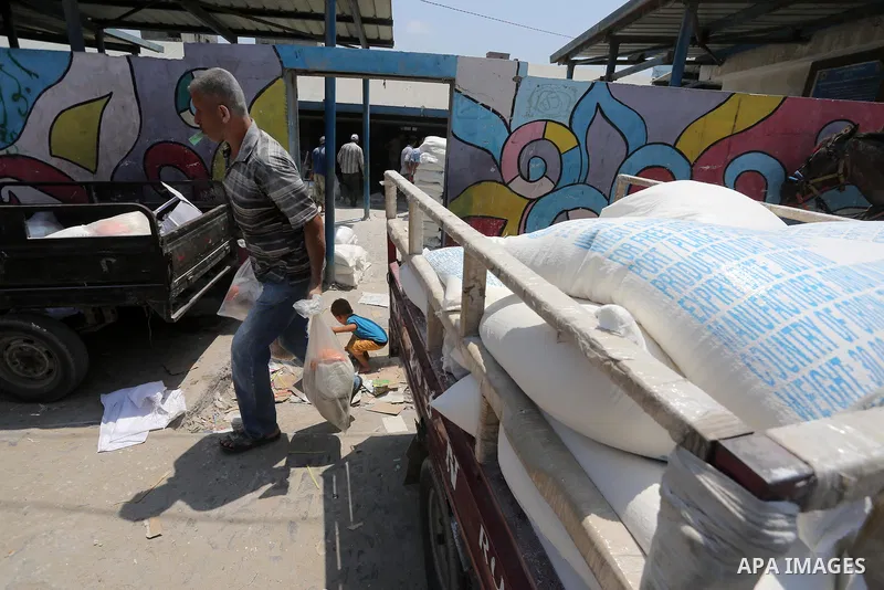 Palestinians receive their monthly food aid at a United Nations distribution center (UNRWA) in Gaza city on August 13, 2017. Photo by Mohammed Asad