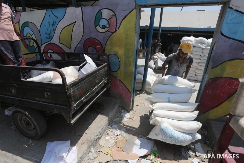 Palestinians receive their monthly food aid at a United Nations distribution center (UNRWA) in Gaza city on August 13, 2017. Photo by Mohammed Asad