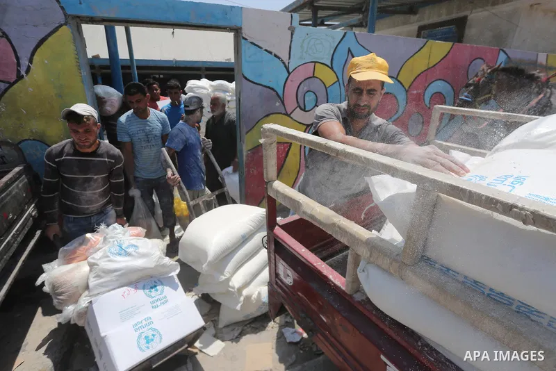 Palestinians receive their monthly food aid at a United Nations distribution center (UNRWA) in Gaza city on August 13, 2017. Photo by Mohammed Asad