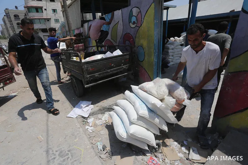 Palestinians receive their monthly food aid at a United Nations distribution center (UNRWA) in Gaza city on August 13, 2017. Photo by Mohammed Asad