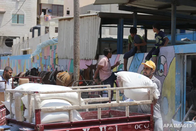 Palestinians receive their monthly food aid at a United Nations distribution center (UNRWA) in Gaza city on August 13, 2017. Photo by Mohammed Asad
