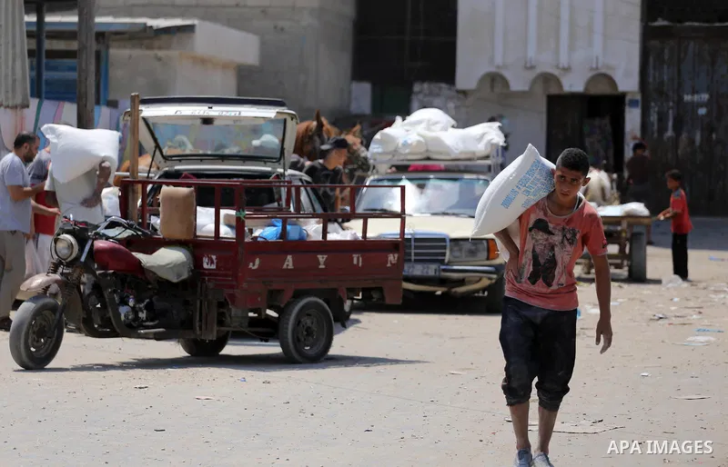 Palestinians receive their monthly food aid at a United Nations distribution center (UNRWA) in Gaza city on August 13, 2017. Photo by Mohammed Asad