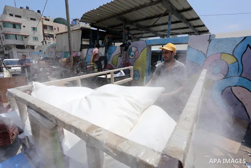 Palestinians receive their monthly food aid at a United Nations distribution center (UNRWA) in Gaza city on August 13, 2017. Photo by Mohammed Asad