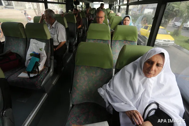 Palestinian Muslim pilgrims wave towards their relatives before leaving for the annual haj pilgrimage to the holy city of Mecca, in Gaza city on August 14, 2017. Photo by Mohammed Asad