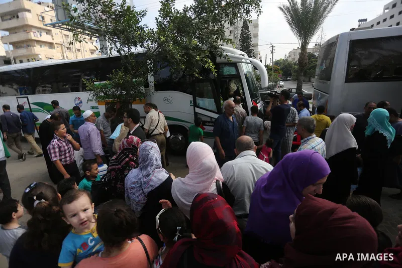 Palestinian Muslim pilgrims wave towards their relatives before leaving for the annual haj pilgrimage to the holy city of Mecca, in Gaza city on August 14, 2017. Photo by Mohammed Asad