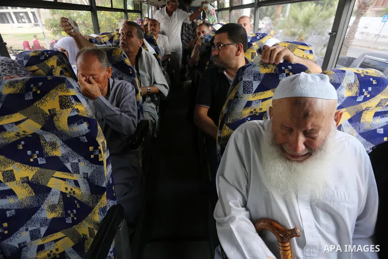 Palestinian Muslim pilgrims wave towards their relatives before leaving for the annual haj pilgrimage to the holy city of Mecca, in Gaza city on August 14, 2017. Photo by Mohammed Asad