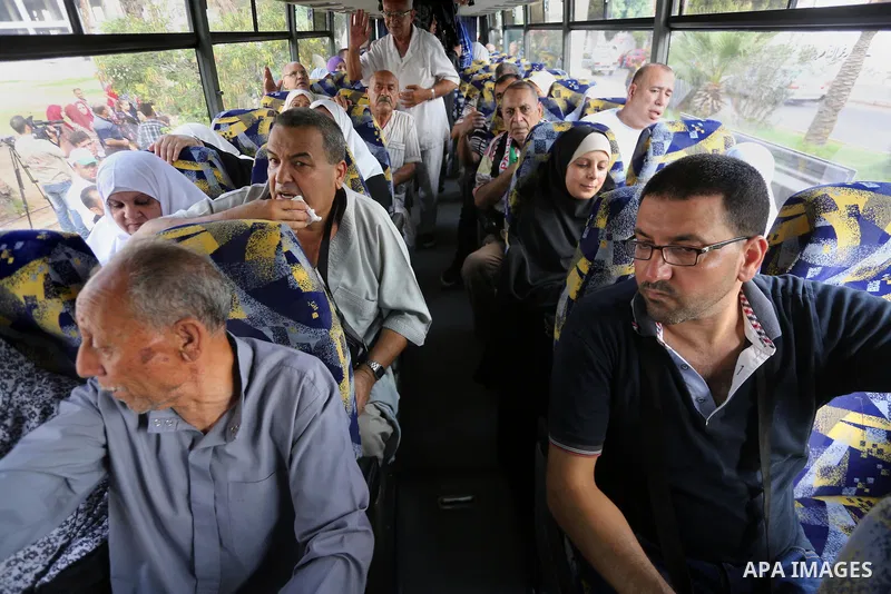 Palestinian Muslim pilgrims wave towards their relatives before leaving for the annual haj pilgrimage to the holy city of Mecca, in Gaza city on August 14, 2017. Photo by Mohammed Asad