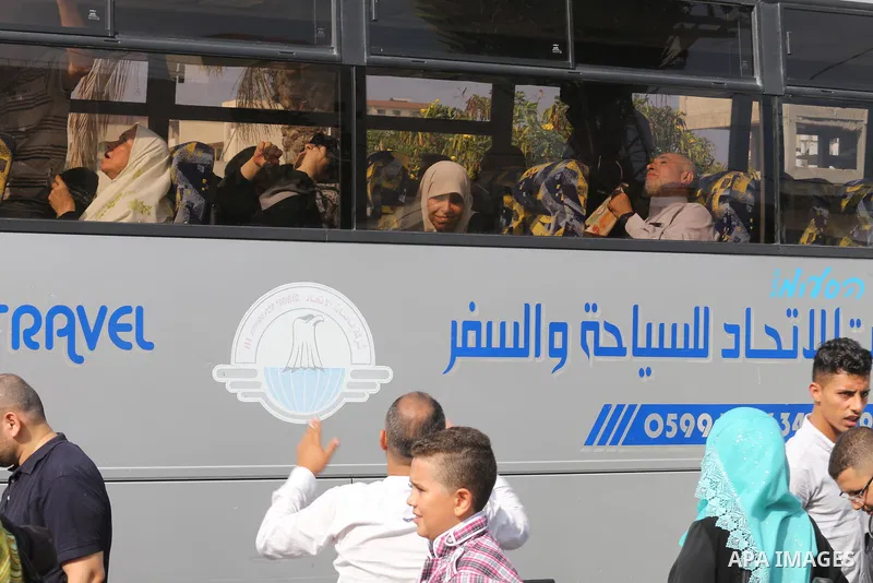 Palestinian Muslim pilgrims wave towards their relatives before leaving for the annual haj pilgrimage to the holy city of Mecca, in Gaza city on August 14, 2017. Photo by Mohammed Asad