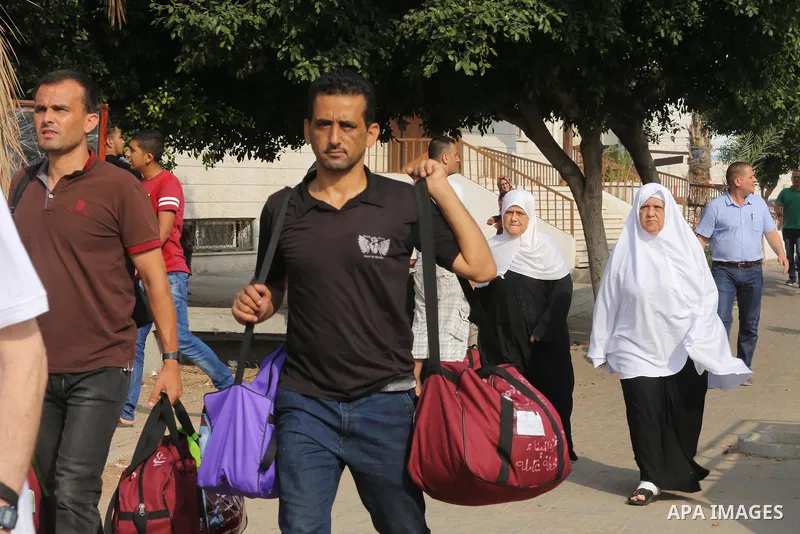 Palestinian Muslim pilgrims wave towards their relatives before leaving for the annual haj pilgrimage to the holy city of Mecca, in Gaza city on August 14, 2017. Photo by Mohammed Asad