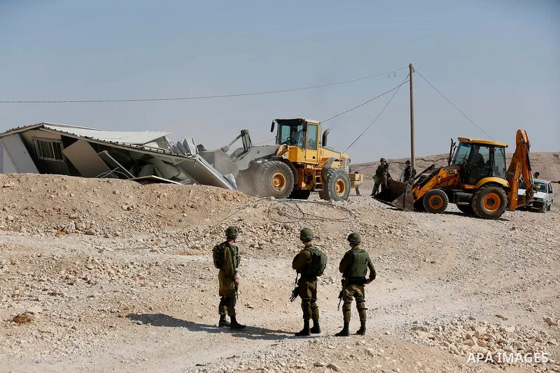 Israeli troops and bulldozers are seen as they demolish a house in the Palestinian bedouin village of Khashm al-Daraj in the southern area of Yatta, south of the West Bank city of Hebron, on August 14, 2017. Photo by Wis...