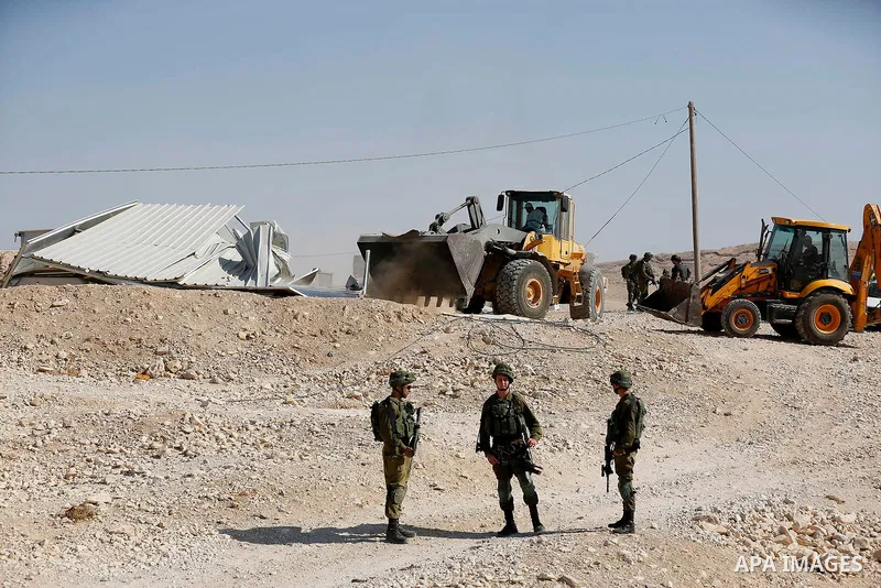 Israeli troops and bulldozers are seen as they demolish a house in the Palestinian bedouin village of Khashm al-Daraj in the southern area of Yatta, south of the West Bank city of Hebron, on August 14, 2017. Photo by Wis...