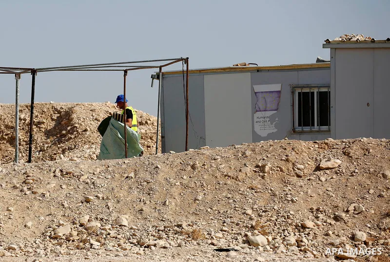 Workers empty EU donated houses in the Palestinian bedouin village of Khashm al-Daraj in the southern area of Yatta, south of the West Bank city of Hebron, on August 14, 2017. Photo by Wisam Hashlamoun