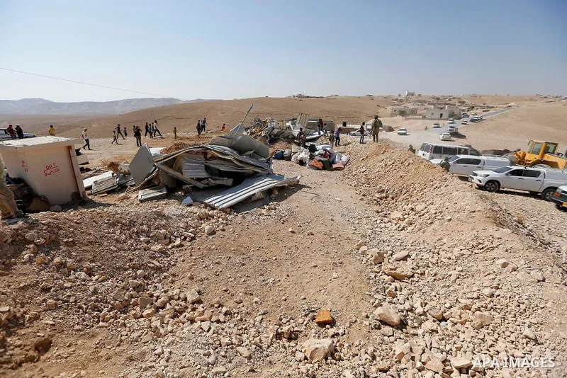 Israeli troops stand past the belongings of Palestinians as they arrive to demolish houses in the bedouin village of Khashm al-Daraj in the southern area of Yatta, south of the West Bank city of Hebron, on August 14, 201...