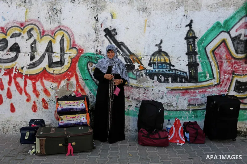 Palestinian Muslim pilgrims wave towards their relatives before leaving for the annual haj pilgrimage to the holy city of Mecca, in Khan Younis in the southern Gaza Strip on August 14, 2017. Photo by Ashraf Amra