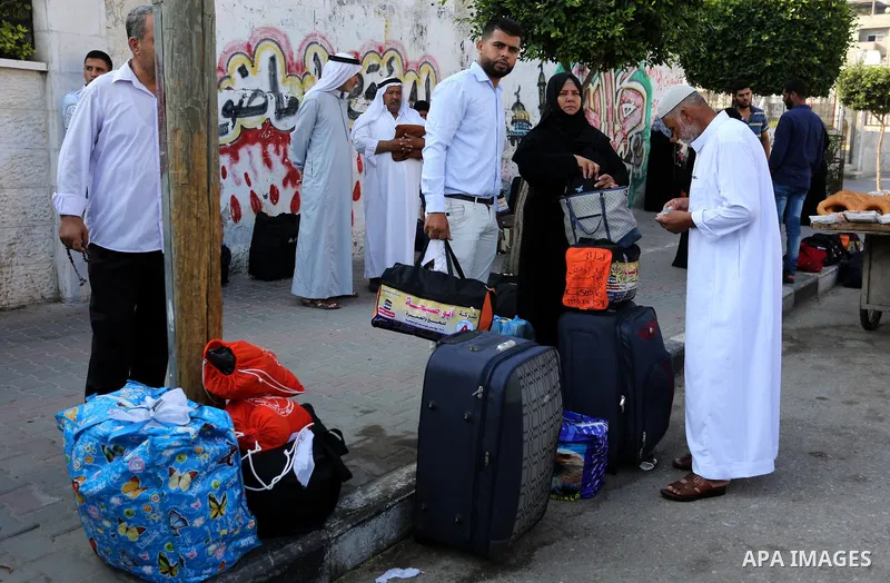 Palestinian Muslim pilgrims wave towards their relatives before leaving for the annual haj pilgrimage to the holy city of Mecca, in Khan Younis in the southern Gaza Strip on August 14, 2017. Photo by Ashraf Amra