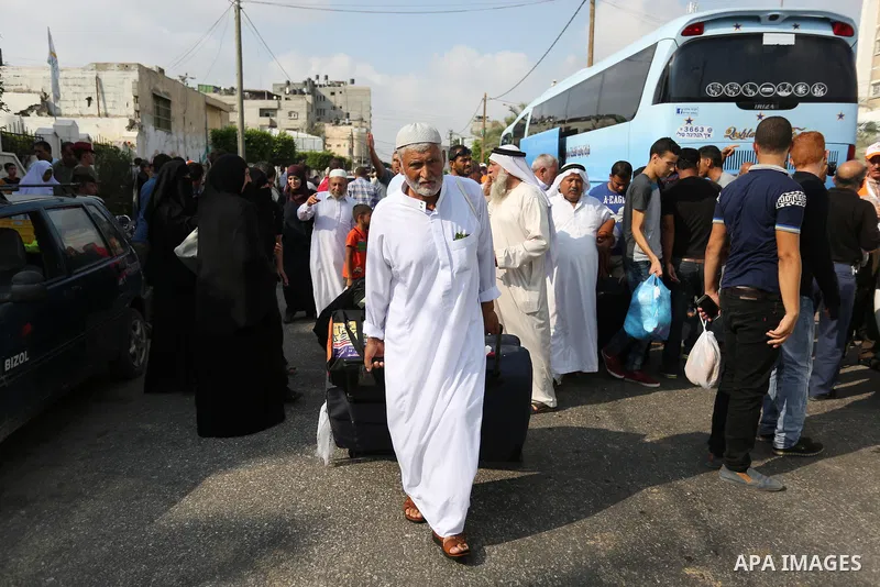 Palestinian Muslim pilgrims wave towards their relatives before leaving for the annual haj pilgrimage to the holy city of Mecca, in Khan Younis in the southern Gaza Strip on August 14, 2017. Photo by Ashraf Amra