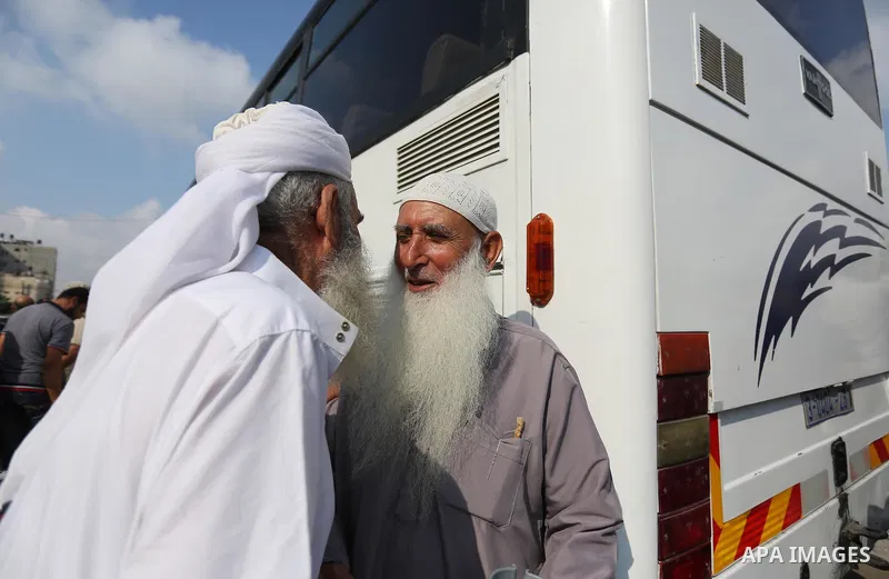 Palestinian Muslim pilgrims wave towards their relatives before leaving for the annual haj pilgrimage to the holy city of Mecca, in Khan Younis in the southern Gaza Strip on August 14, 2017. Photo by Ashraf Amra