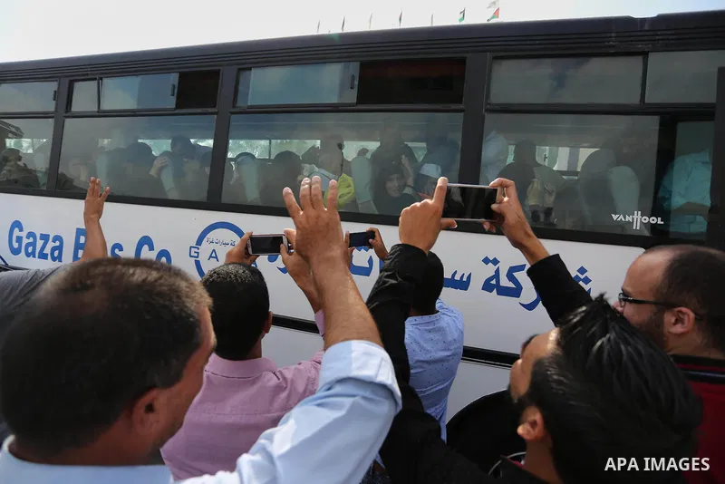 Palestinian Muslim pilgrims wave towards their relatives before leaving for the annual haj pilgrimage to the holy city of Mecca, in Khan Younis in the southern Gaza Strip on August 14, 2017. Photo by Ashraf Amra