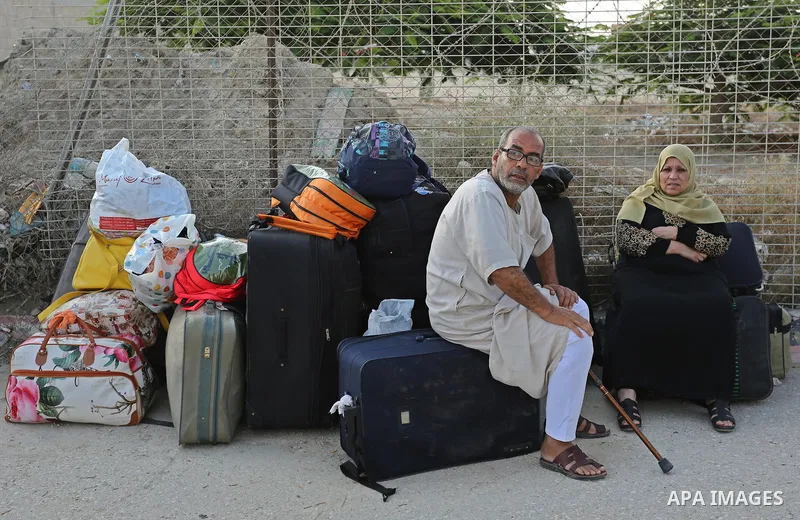 Palestinians wait for travel permits to cross into Egypt through the Rafah border crossing after it was opened by Egyptian authorities for humanitarian cases, in Rafah in the southern Gaza Strip on August 16, 2017. Photo...