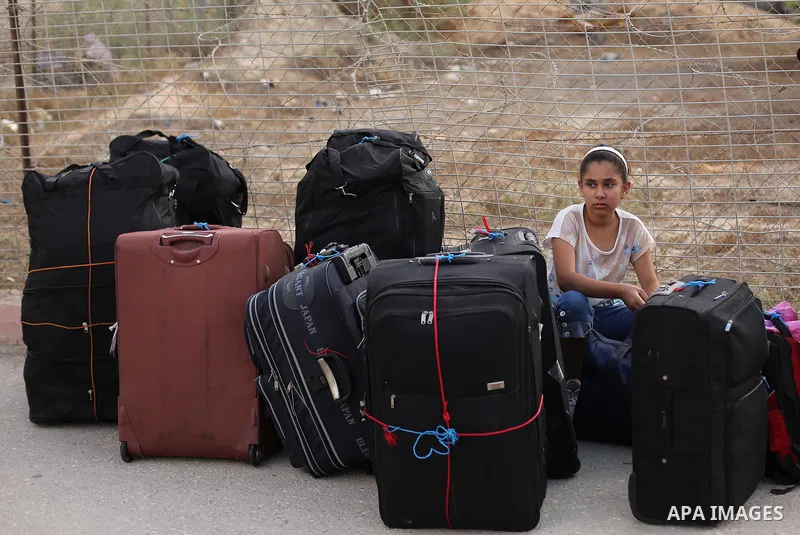 Palestinians wait for travel permits to cross into Egypt through the Rafah border crossing after it was opened by Egyptian authorities for humanitarian cases, in Rafah in the southern Gaza Strip on August 16, 2017. Photo...