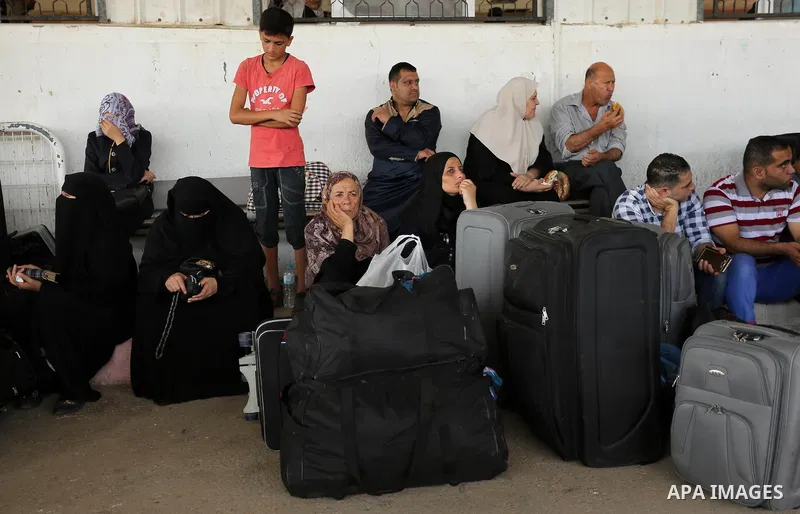 Palestinians wait for travel permits to cross into Egypt through the Rafah border crossing after it was opened by Egyptian authorities for humanitarian cases, in Rafah in the southern Gaza Strip on August 16, 2017. Photo...