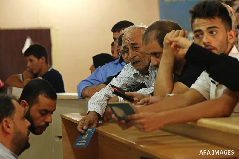 Palestinians wait for travel permits to cross into Egypt through the Rafah border crossing after it was opened by Egyptian authorities for humanitarian cases, in Rafah in the southern Gaza Strip on August 16, 2017. Photo...