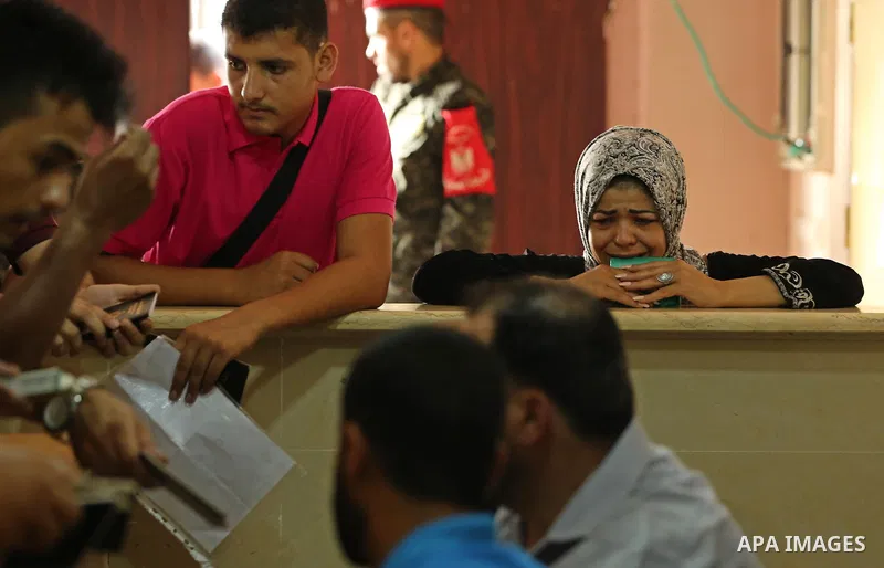 Palestinians wait for travel permits to cross into Egypt through the Rafah border crossing after it was opened by Egyptian authorities for humanitarian cases, in Rafah in the southern Gaza Strip on August 16, 2017. Photo...