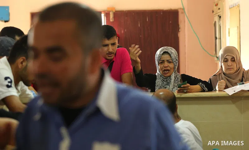 Palestinians wait for travel permits to cross into Egypt through the Rafah border crossing after it was opened by Egyptian authorities for humanitarian cases, in Rafah in the southern Gaza Strip on August 16, 2017. Photo...