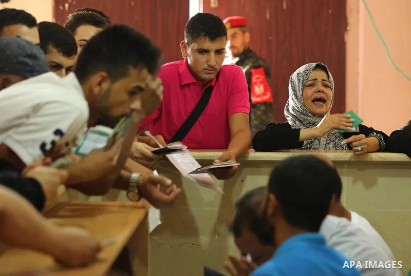 Palestinians wait for travel permits to cross into Egypt through the Rafah border crossing after it was opened by Egyptian authorities for humanitarian cases, in Rafah in the southern Gaza Strip on August 16, 2017. Photo...