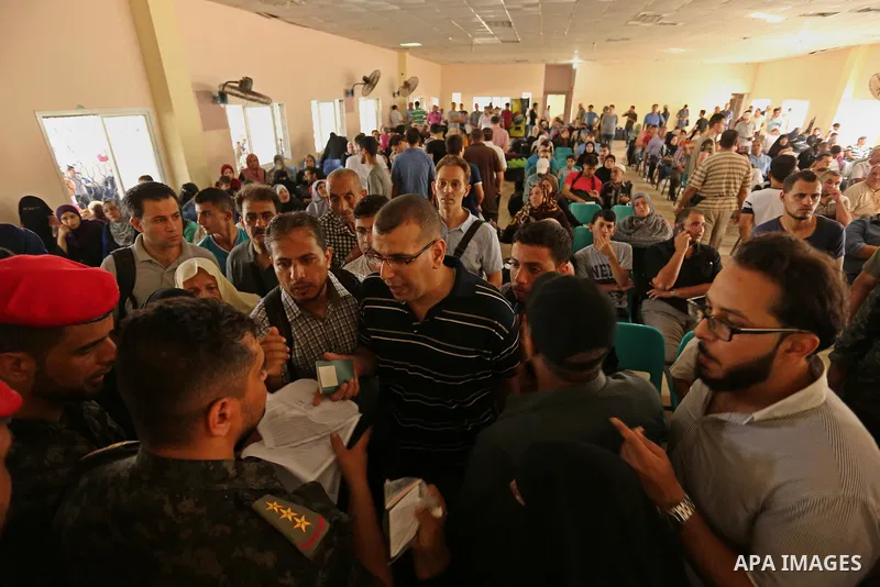 Palestinians wait for travel permits to cross into Egypt through the Rafah border crossing after it was opened by Egyptian authorities for humanitarian cases, in Rafah in the southern Gaza Strip on August 16, 2017. Photo...