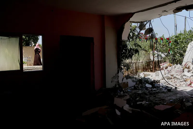 A woman walks next to the remains of the family house of Palestinian assailant Omar Alabed after it was demolished by Israeli troops in the West Bank village of Khobar near Ramallah August 16, 2017. Photo by Shadi Hatem