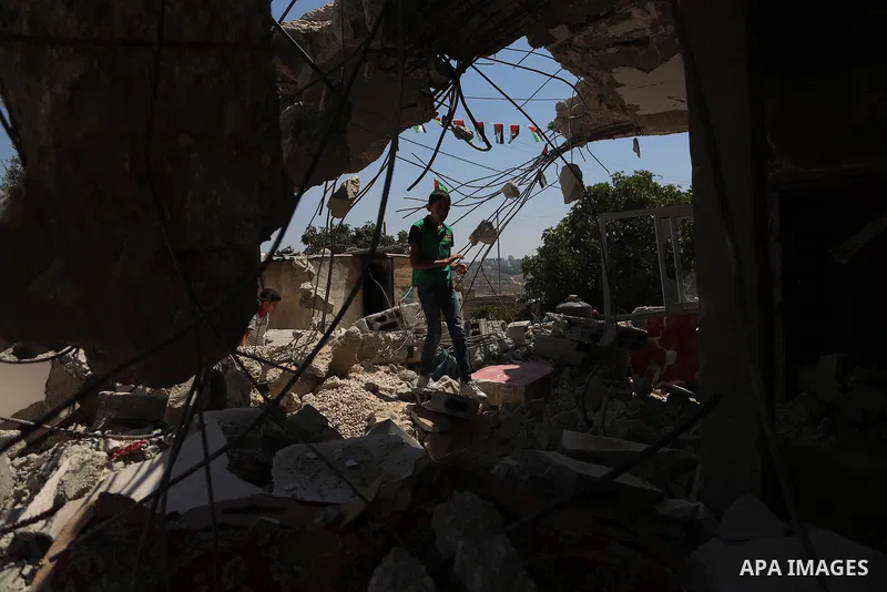 A boy walks next to the remains of the family house of Palestinian assailant Omar Alabed after it was demolished by Israeli troops in the West Bank village of Khobar near Ramallah August 16, 2017. Photo by Shadi Hatem
