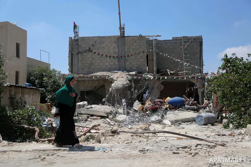 A woman walks next to the remains of the family house of Palestinian assailant Omar Alabed after it was demolished by Israeli troops in the West Bank village of Khobar near Ramallah August 16, 2017. Photo by Shadi Hatem