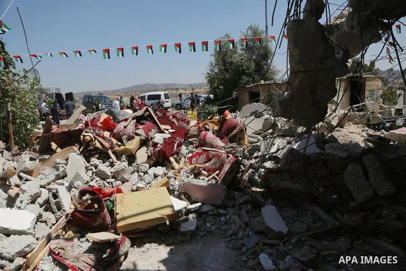 People check the remains of the house of a Palestinian man, who killed three Jewish residents of a nearby Israeli settlement, after it was demolished by Israeli authorities in the West Bank village of Kobar, near Ramalla...
