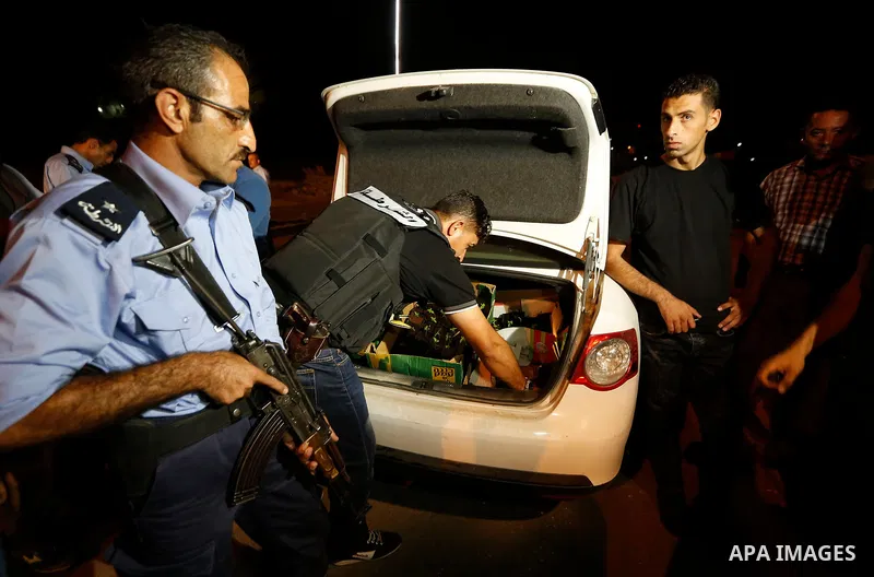 Palestinian policemen carry cannabis plants during a drug patrol in the West Bank city of Hebron, on August 16, 2017. Photo by Wisam Hashlamoun