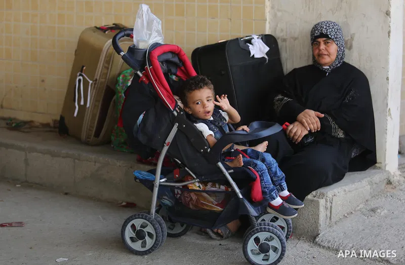 Palestinians wait for travel permits to cross into Egypt through the Rafah border crossing after it was opened by Egyptian authorities for humanitarian cases, in Rafah in the southern Gaza Strip on Gaza Strip August 17,...