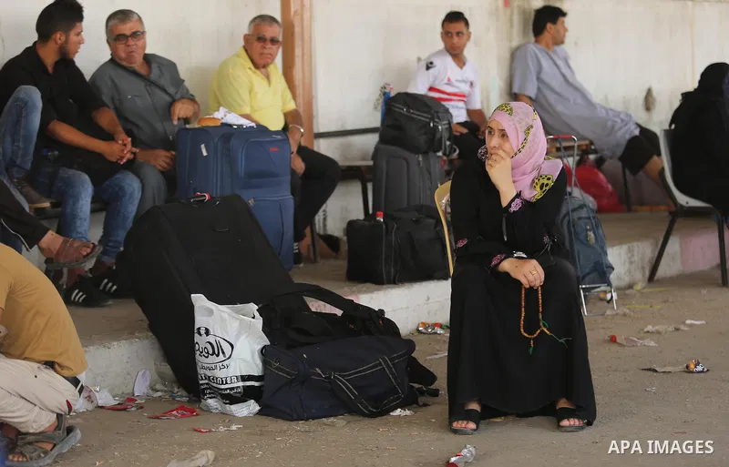 Palestinians wait for travel permits to cross into Egypt through the Rafah border crossing after it was opened by Egyptian authorities for humanitarian cases, in Rafah in the southern Gaza Strip on Gaza Strip August 17,...