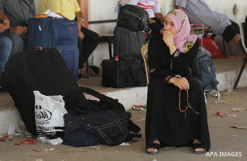 Palestinians wait for travel permits to cross into Egypt through the Rafah border crossing after it was opened by Egyptian authorities for humanitarian cases, in Rafah in the southern Gaza Strip on Gaza Strip August 17,...