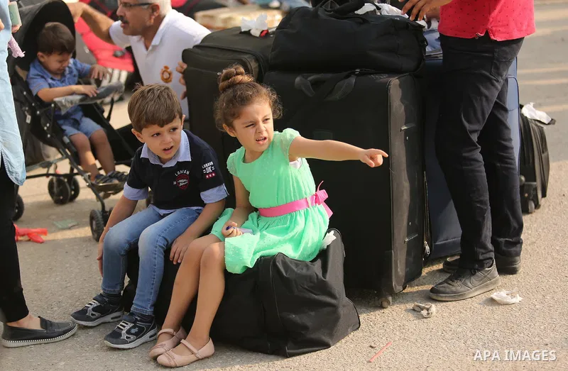 Palestinians wait for travel permits to cross into Egypt through the Rafah border crossing after it was opened by Egyptian authorities for humanitarian cases, in Rafah in the southern Gaza Strip on Gaza Strip August 17,...