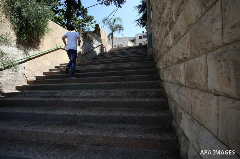 A Palestinian man walks up stairs to reach the markets in the Old city of the West Bank city of Nablus on August 17, 2017. Nablus city is located between two mountains where hundreds of houses are built to face the incre...
