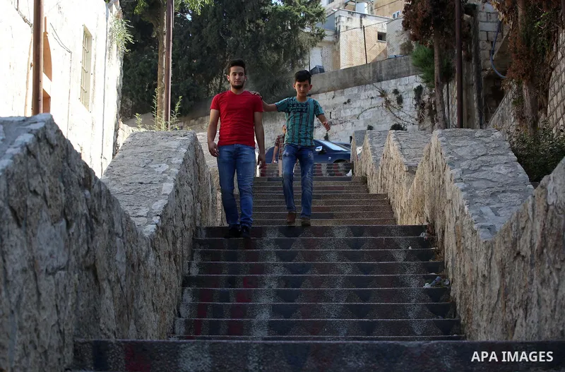 Palestinians walk down stairs to reach the markets in the Old city of the West Bank city of Nablus on August 17, 2017. Nablus city is located between two mountains where hundreds of houses are built to face the increase...