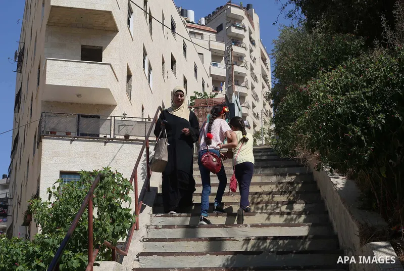 Palestinians walk down stairs to reach the markets in the Old city of the West Bank city of Nablus on August 17, 2017. Nablus city is located between two mountains where hundreds of houses are built to face the increase...