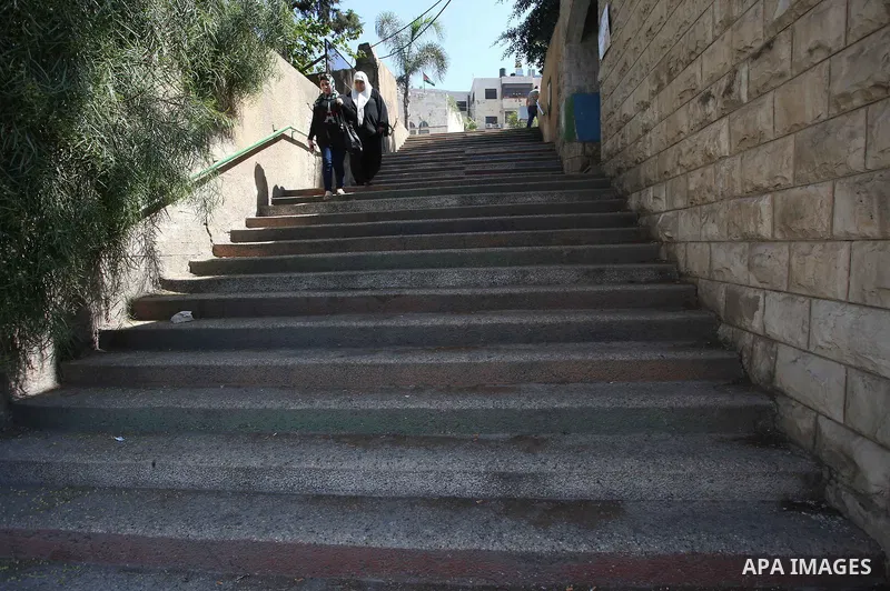 Palestinians walk down stairs to reach the markets in the Old city of the West Bank city of Nablus on August 17, 2017. Nablus city is located between two mountains where hundreds of houses are built to face the increase...