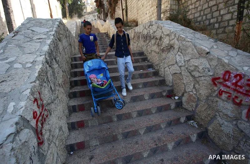 Palestinians walk down stairs to reach the markets in the Old city of the West Bank city of Nablus on August 17, 2017. Nablus city is located between two mountains where hundreds of houses are built to face the increase...