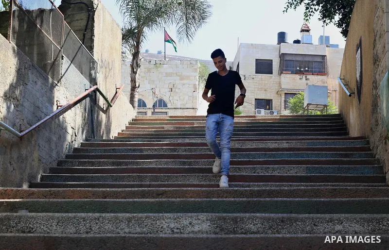 A Palestinian man walks down stairs to reach the markets in the Old city of the West Bank city of Nablus on August 17, 2017. Nablus city is located between two mountains where hundreds of houses are built to face the inc...