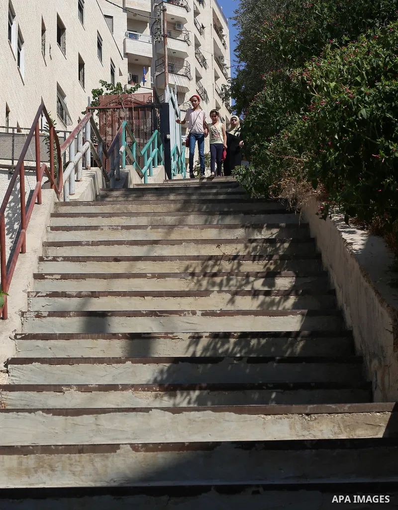 Palestinians walk down stairs to reach the markets in the Old city of the West Bank city of Nablus on August 17, 2017. Nablus city is located between two mountains where hundreds of houses are built to face the increase...